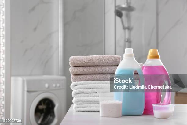 Stack Of Folded Towels And Detergents On White Table In Bathroom Stock Photo - Download Image Now