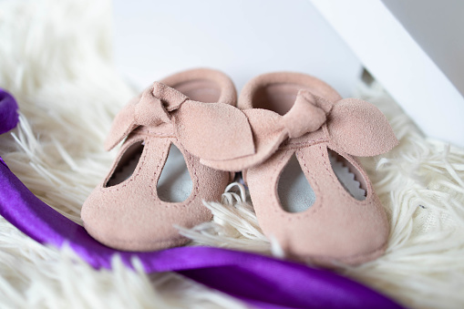 Small pink shoes for unborn baby on the table