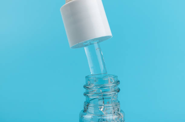 istock face serum drop with bottle on blue background. 1329033141