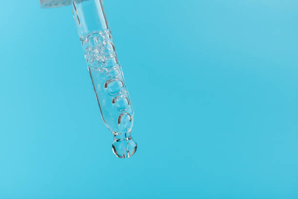 istock face serum drop with bottle on blue background. 1329033159