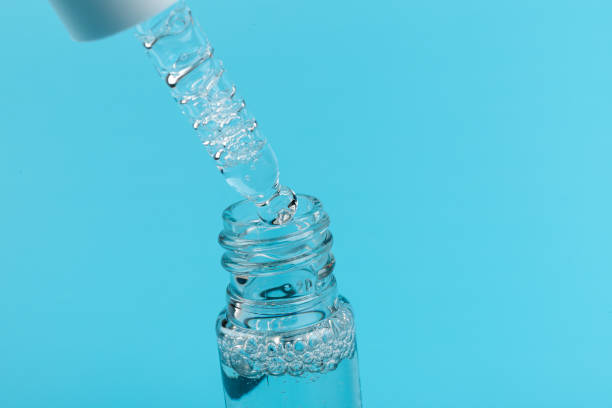 istock face serum drop with bottle on blue background. 1329033230