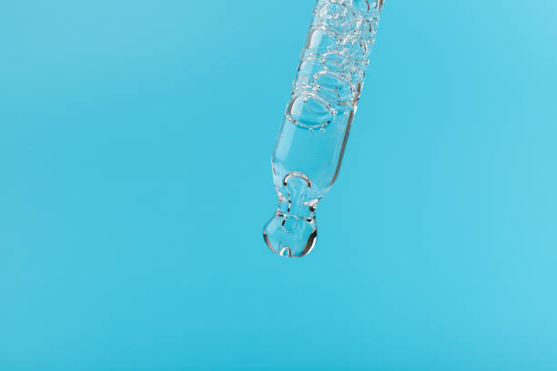 istock face serum drop with bottle on blue background. 1329033234