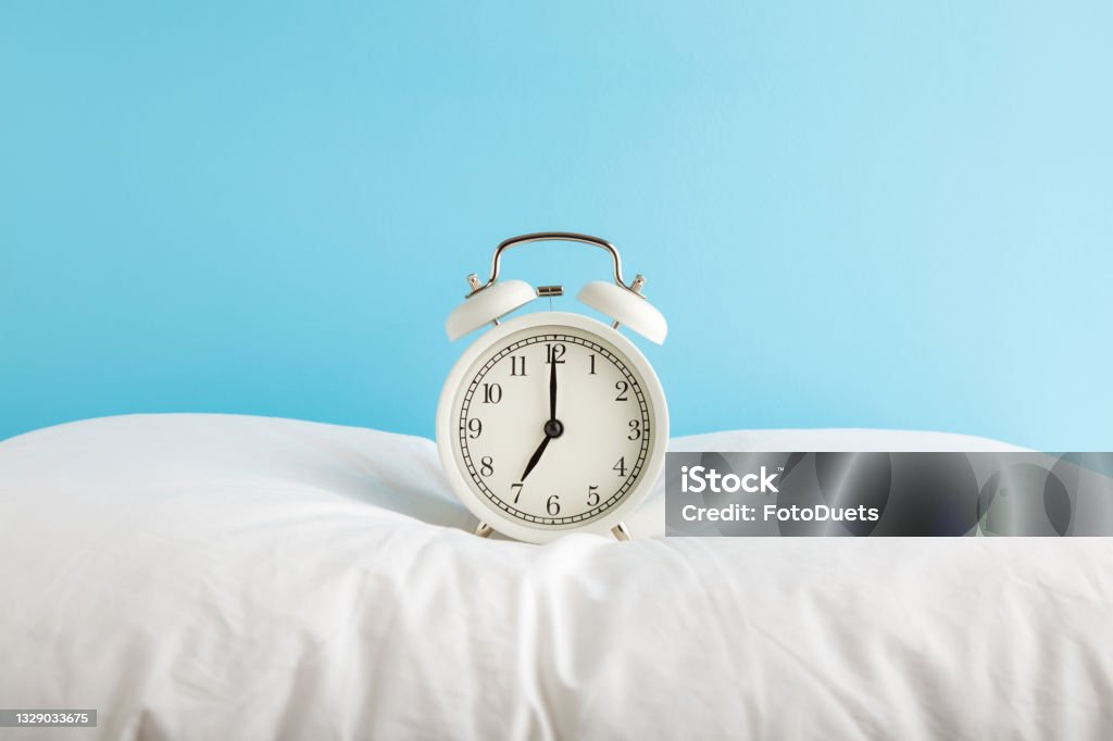 White Alarm Clock On Pillow At Light Blue Wall Background Pastel Color 7 Oclock In Morning Waking Time Concept Front View Stock - Now - iStock