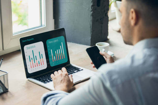 istock Cropped image of one young businessman looking at statistics graph on laptop. Back view 1329035649