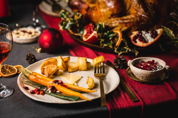 Unfinished Christmas meal Unfinished Christmas meal in the plate. Fried carrots, roasted potatoes and pomegranates with a fork in dinner plate on table. leftovers photos stock pictures, royalty-free photos & images