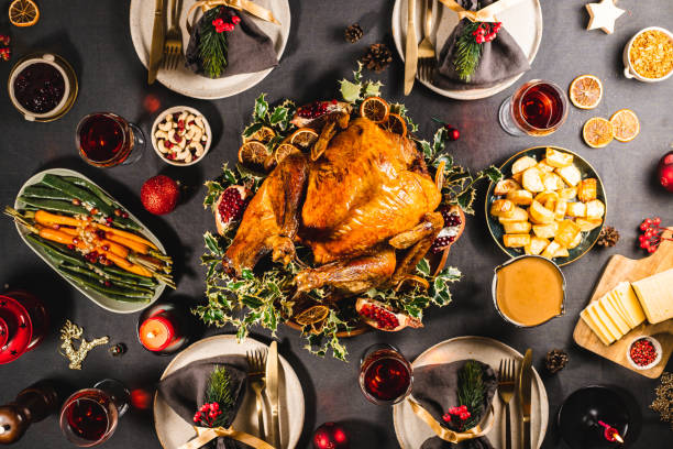 Traditional Christmas Eve dinner on table Directly above view of a delicious Christmas meal with roasted Turkey, carrots, cashews, pomegranates, dried oranges and red wine on the dinner table. cashew photos stock pictures, royalty-free photos & images
