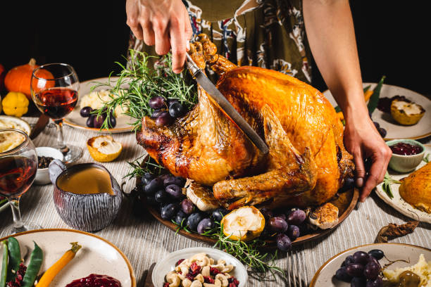 istock Woman carving roasted turkey for Thanksgiving dinner 1329037317