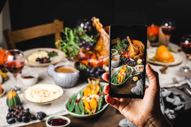 Hand taking photos of thanksgiving dinner with a smartphone