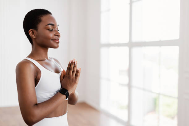 istock Black lady meditating keeping hands together in prayer pose 1329037356