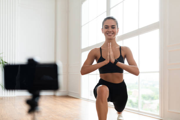 istock Young woman doing forward lunges in front of smartphone 1329037983