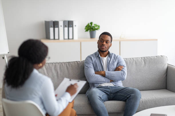 psychologische beratung. schwarzer männlicher patient mit depressionen bei einer sitzung mit psychotherapeut im büro - psychosoziale beratung stock-fotos und bilder