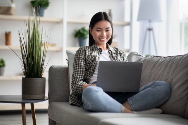 istock Glad asian lady using brand new laptop at home 1329038311
