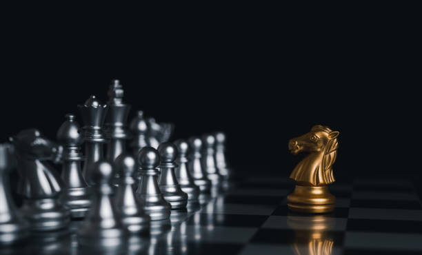 istock Gold king winner surrounded with silver chess pieces on chess board game competition.concept strategy, leadership and success business. 1329038339