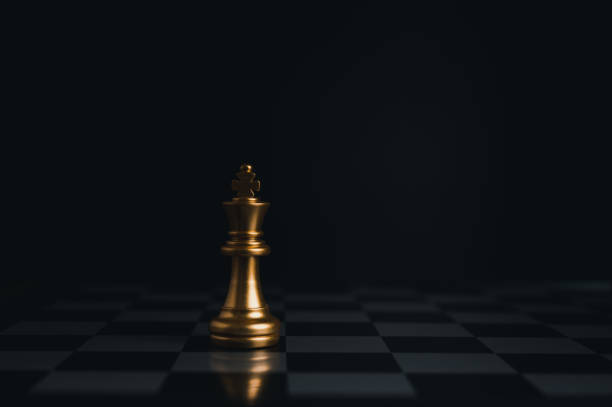 istock Gold king winner surrounded with silver chess pieces on chess board game competition.concept strategy, leadership and success business. 1329038407