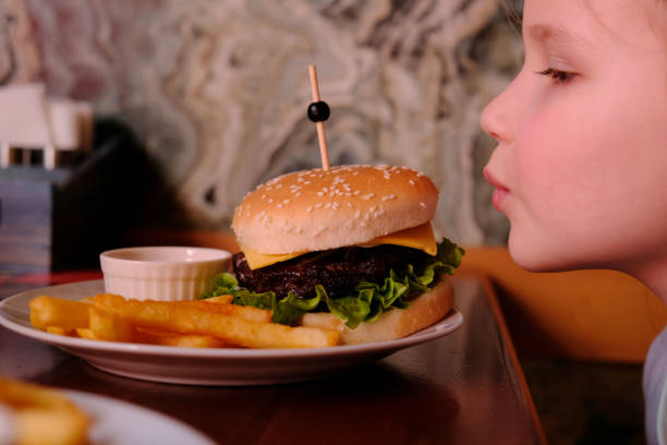 istock Little girl with hamburger.  Ready to eat. 1329038600