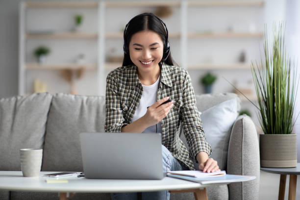 istock Pretty asian woman attending video conference with co-workers 1329039920