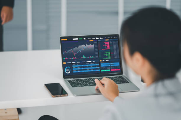 istock Young money businessman sitting staring at a computer screen displaying a cryptocurrency featuring stock tickers or graphs. Stock trading platform concept. professional financial advisor. 1329040954