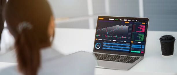 istock Young money businessman sitting staring at a computer screen displaying a cryptocurrency featuring stock tickers or graphs. Stock trading platform concept. professional financial advisor. 1329041020