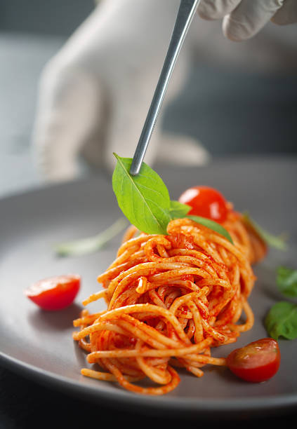istock Decorating pasta in tomato sauce with green leaves 1329047074