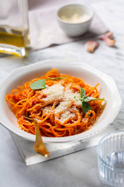 istock A person's hands are sprinkled with parmesan cheese pasta in tomato sauce 1329047078
