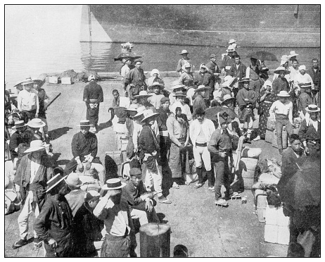 Antique black and white photograph of people from islands in the Caribbean and in the Pacific Ocean; Cuba, Hawaii, Philippines and others: Japanese contract laborers at Honolulu harbor, Hawaii