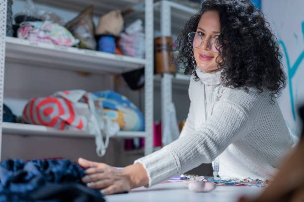 istock Enterprising female designer looking at the camera in a portrait while making her designs at home 1329048229