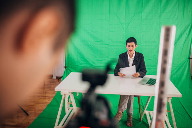 istock Woman anchor reading news in studio 1329052820