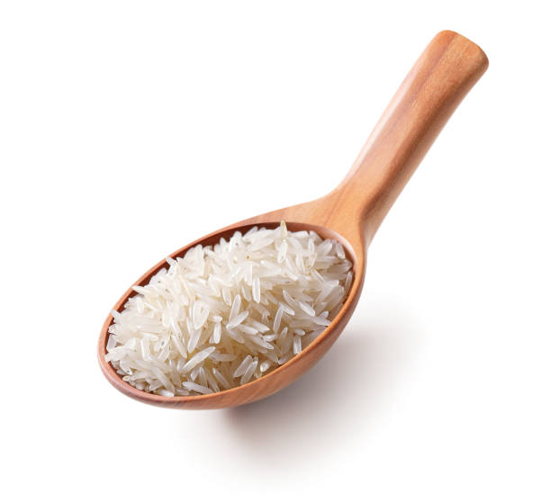 riso bianco in un cucchiaio di legno isolato su sfondo bianco. - clipping path rice white rice basmati rice foto e immagini stock