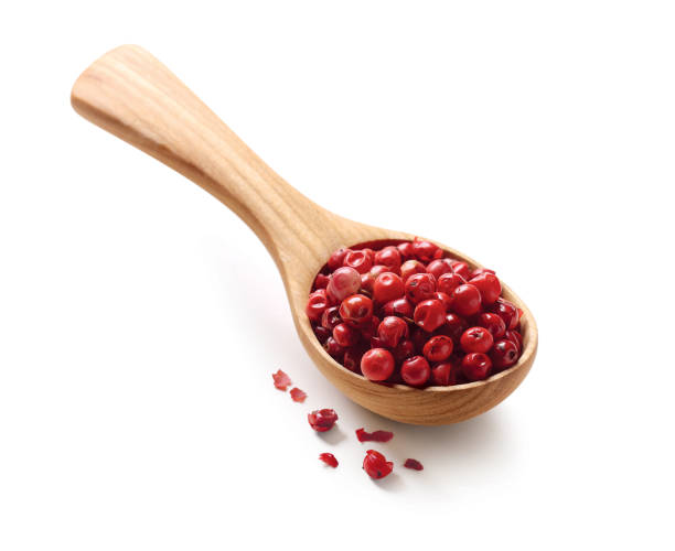 red, pink peppercorns in a wooden spoon isolated on white background. - pink peppercorn imagens e fotografias de stock