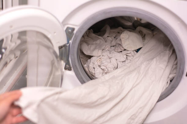 istock Close-up of pulling out white linen from the washing machine 1329057277
