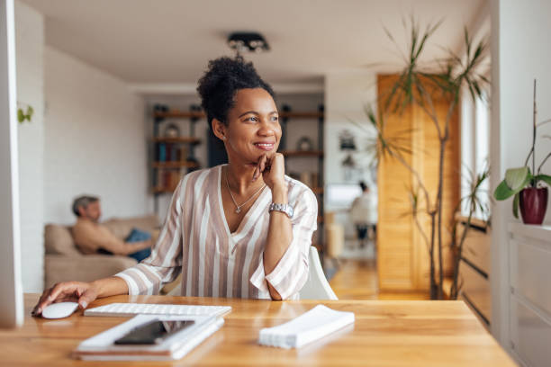 Adult black woman, making sure her company prospers. Happy adult woman, leading her company, from home office prosperity stock pictures, royalty-free photos & images