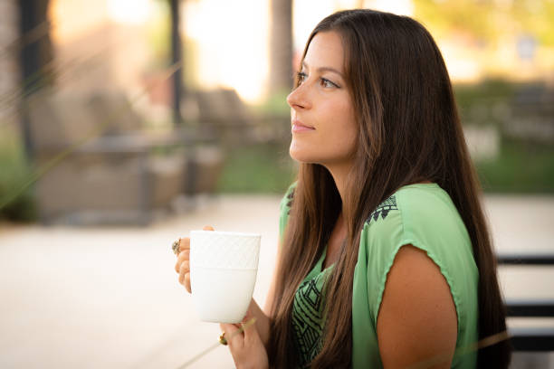 istock Beautiful Pretty Young Brunette Woman Thinking Drinking Coffee Outdoors in White Cup with Natural Soft Daylight at Mall Café Outside 1329058443