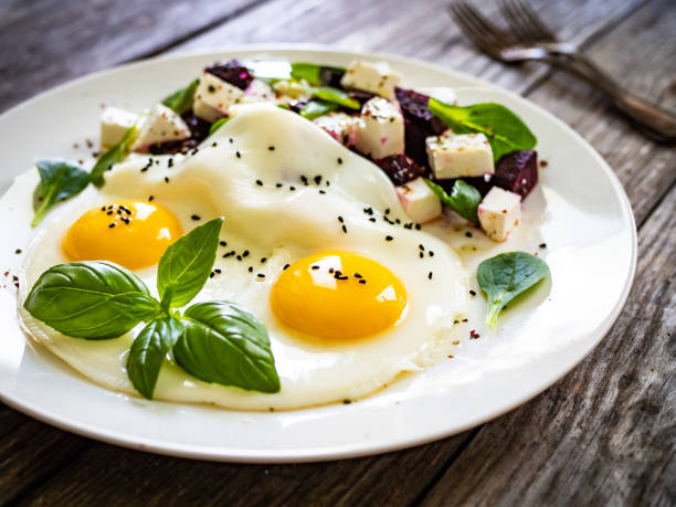 istock Continental breakfast -  fried eggs and vegetables on wooden table 1329058735