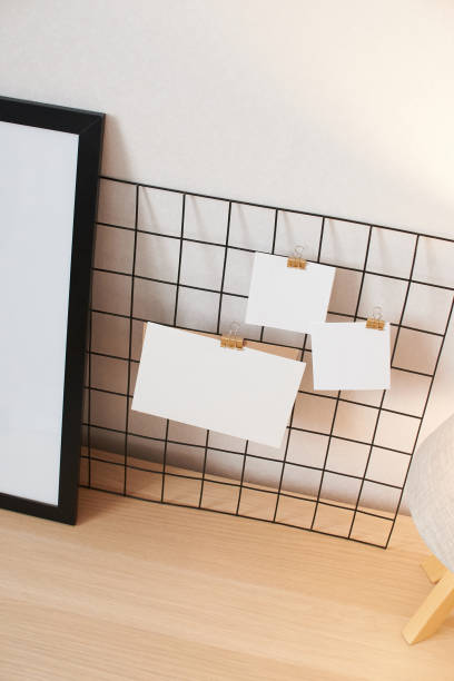 istock Cards and posters mock ups on black grid board. Blank paper attached with binder. 1329061640