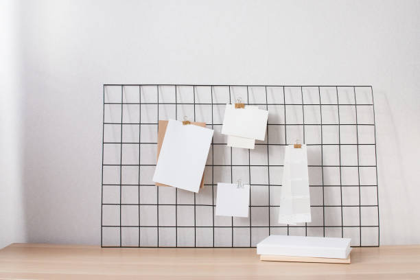 istock Cards and posters mock ups on black grid board. Blank paper in different sizes and color palette attached with binder. 1329061643