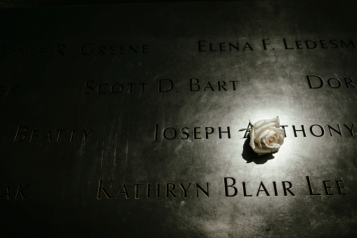 New York City, USA - July 6, 2016: A rose is left at the National September 11 Memorial at Ground Zero in Lower Manhattan. The names of the victims of that day are inscribed.