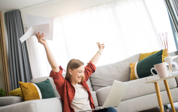 istock Cheerful young woman working at home and celebrating. 1329065682