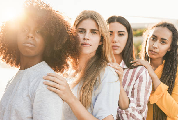 beautiful multiracial women looking on camera with sunset in the background - girls with different ethnic and skin colors - life events laughing women latin american and hispanic ethnicity imagens e fotografias de stock