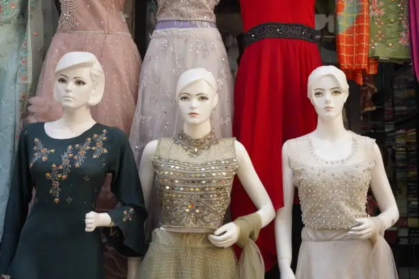 Photo of Mannequins dressed in latest Indian clothes in front of a retail cloth shop.