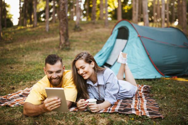 istock Happy couple having video call while camping in forest 1329073537