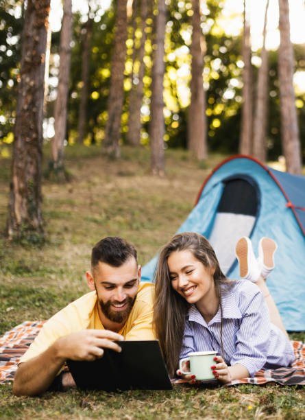 istock Romantic couple camping, resting and reading a book 1329073802