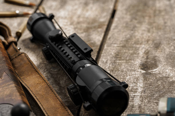 istock The optical sight and shotgun on wooden backgorund 1329074035