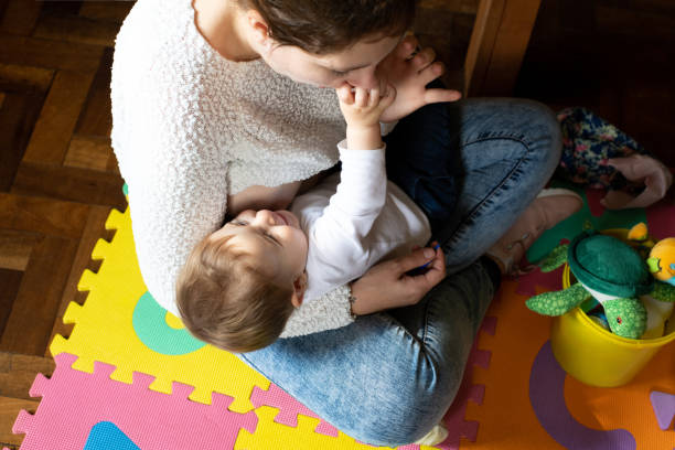 istock Baby playing with mother while breast-feeding. 1329074556