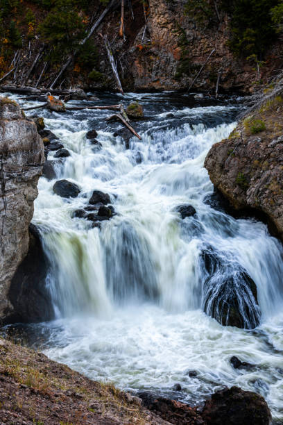 istock Flowing waterfall in blurry motion over black rock river. 1329074795