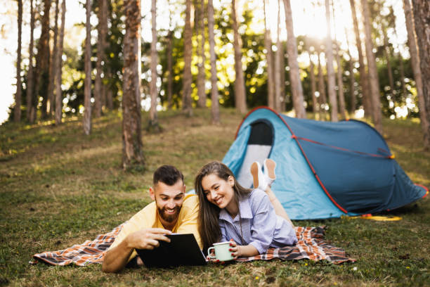 istock Romantic couple camping, resting and reading a book 1329078461
