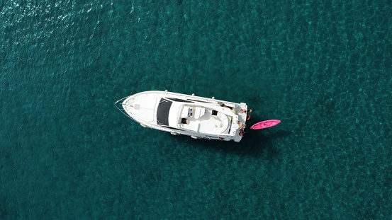 Aerial view of a pleasure boat at sea.  Pink inflatable float at the stern of the boat