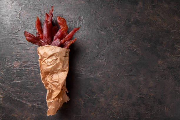 jerky meat strips with spices and herbs on a paper - beef jerky meat smoked imagens e fotografias de stock