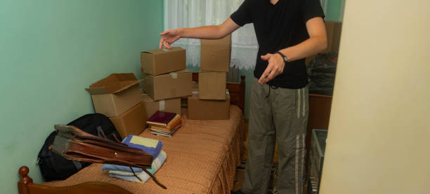 istock Student moving in to his dorm, starting his student life, entering his room with boxes, arranging his stuff. 1329084174