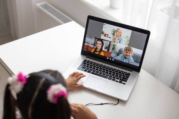 istock Little girl studying online using her laptop at home 1329088247