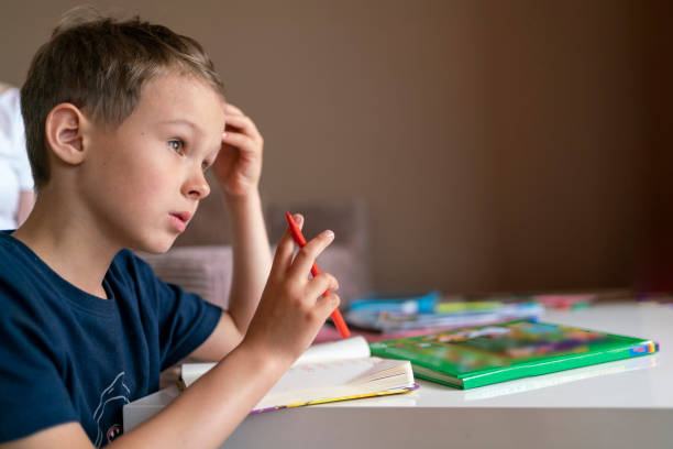 istock child boy with dark hair studies at home. child doing homework 1329093904